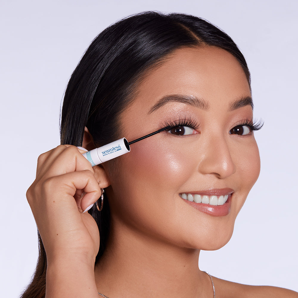 Model trägt Seamless Bond & Seal Wimpernkleber mit Applikator am Wimpernkranz auf
