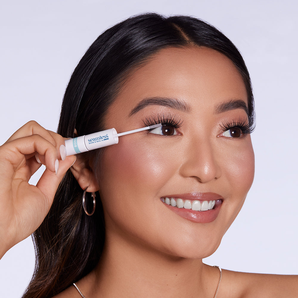 Model versiegelt künstliche Wimpern mit Seamless Bond & Seal Applikator