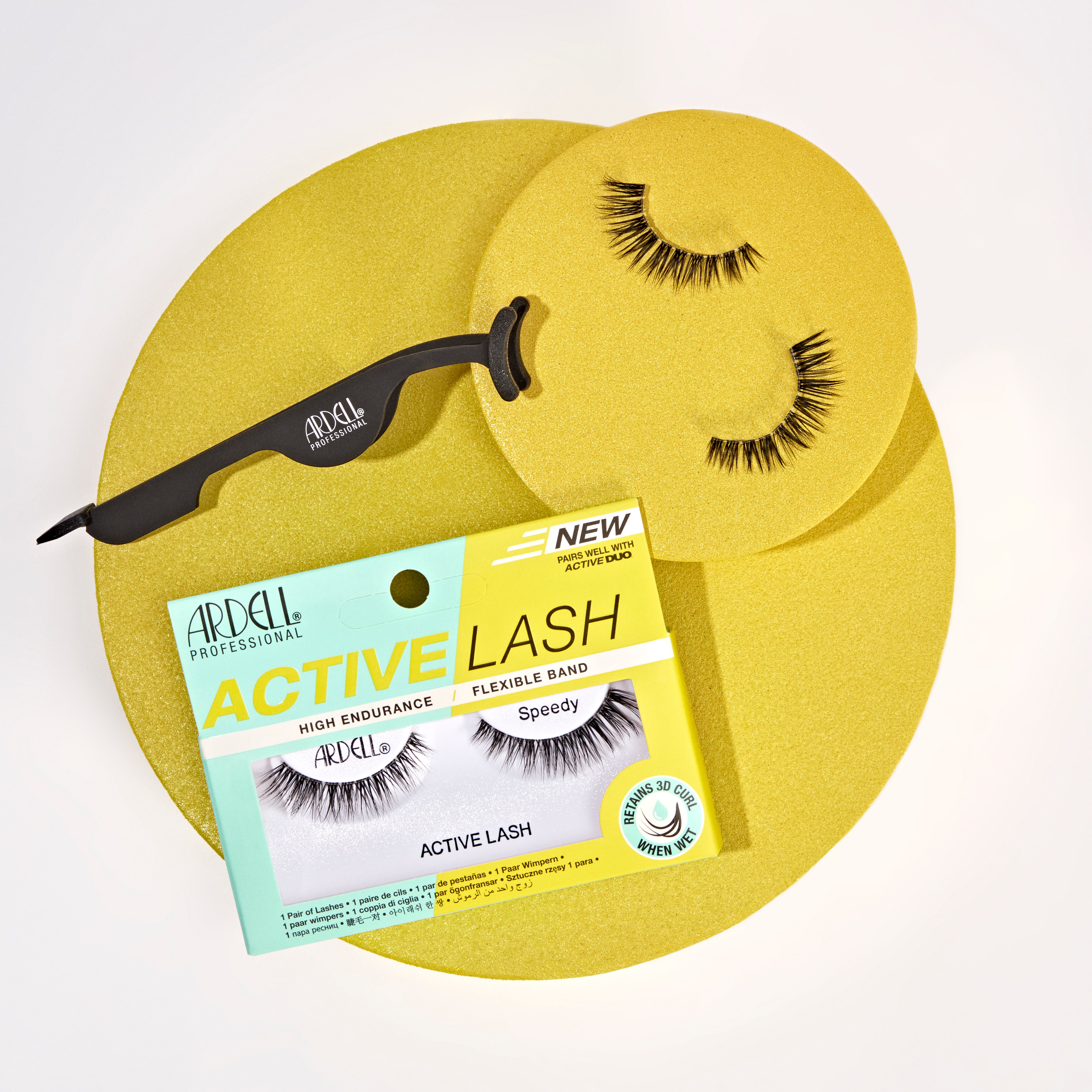 Ardell Active Lash Speedy künstliche Wimpern, schwarze Lash-Applikatorzange und loses Wimpernpaar auf goldenen runden Flächen