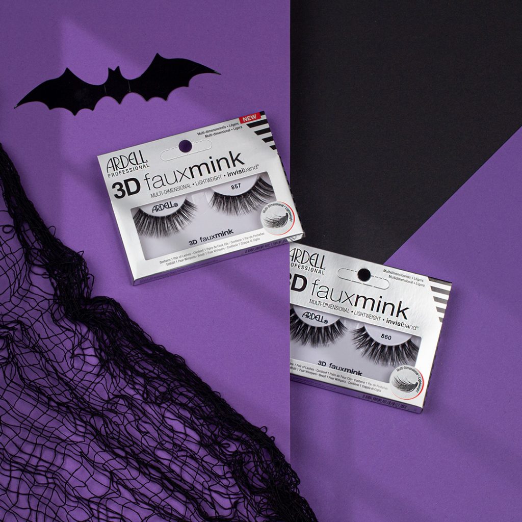 Auf lila Hintergrund liegen zwei Packung der ARDELL fauxmink 856 Wimpern. Eine Fledermaus zum Thema Halloween Make Up fliegt darüber.